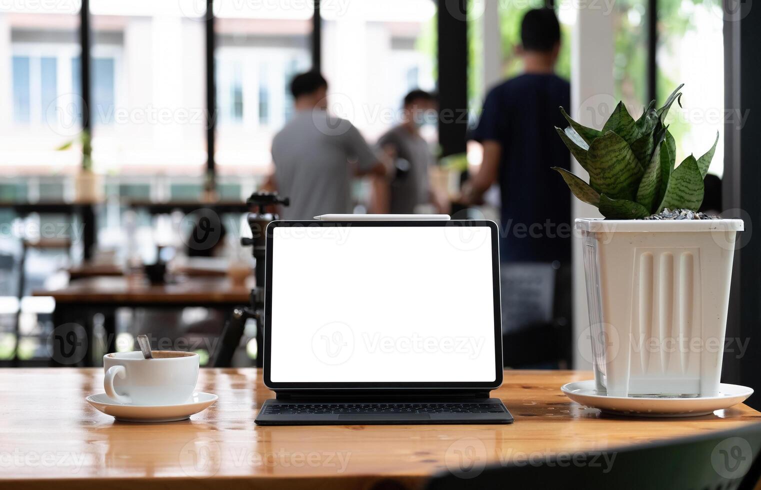 Shot of blank screen tablet with keyboard on wooden desk in office photo