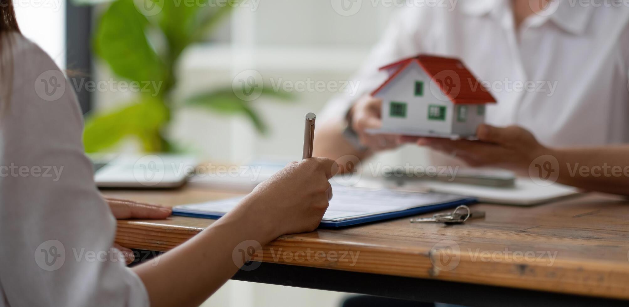 Estate agent give house model to customer after finished contract after about home insurance and investment loan photo