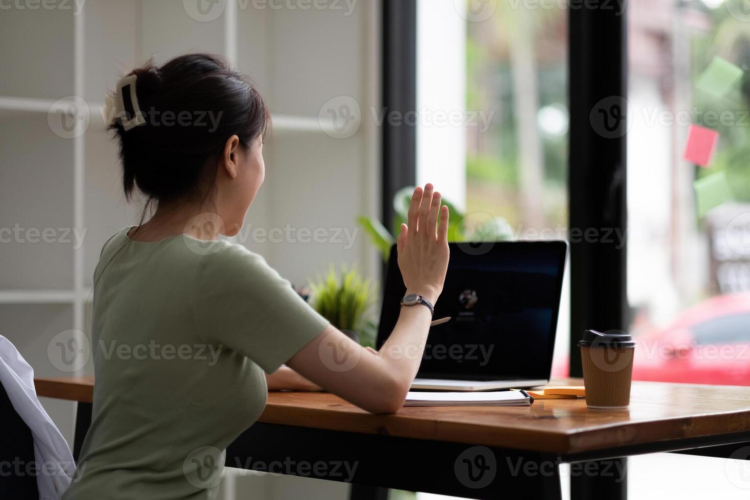 Cropped view of woman waving hand while having call with laptop computer photo