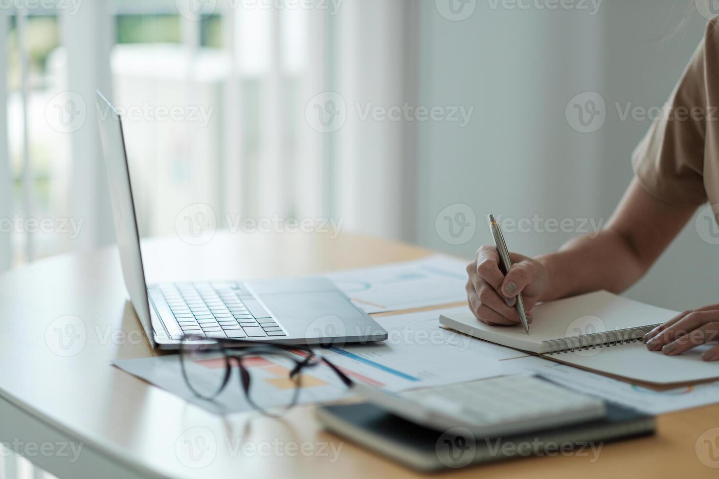 accountant woman working audit and calculating expense financial annual financial report balance sheet statement, doing finance making notes on paper checking document. photo