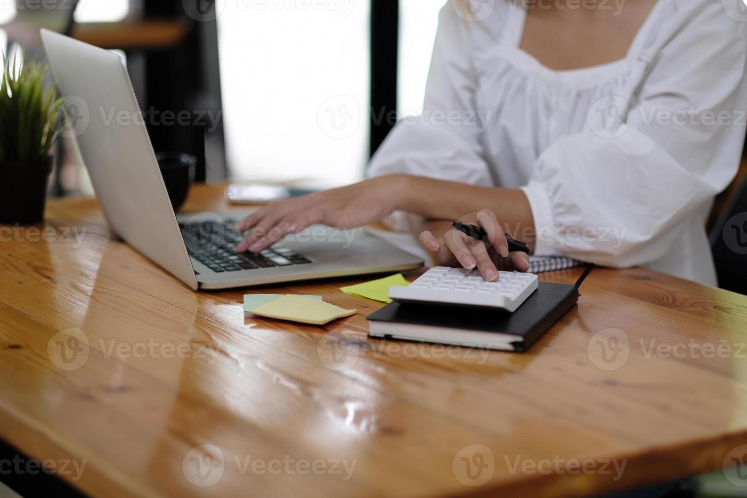 Business woman using calculator to calculate the numbers in the company financial documents, the finance department prepares the document and forwards it to be checked before the meeting photo