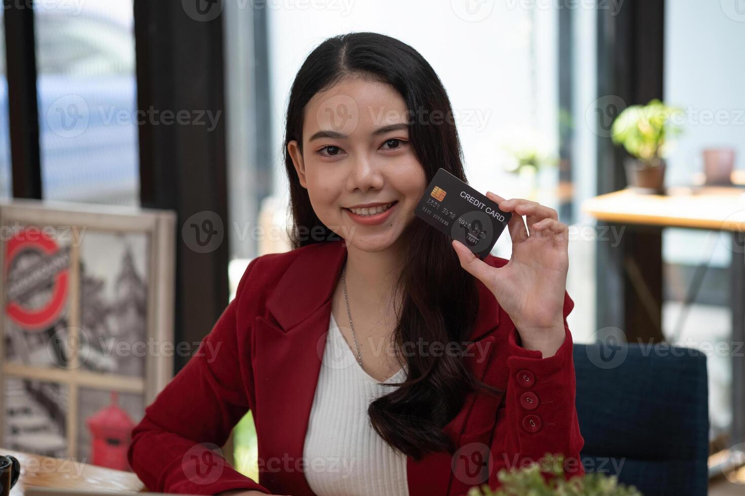 Charming asian woman showing credit card looking on camera. Online banking shopping concept photo