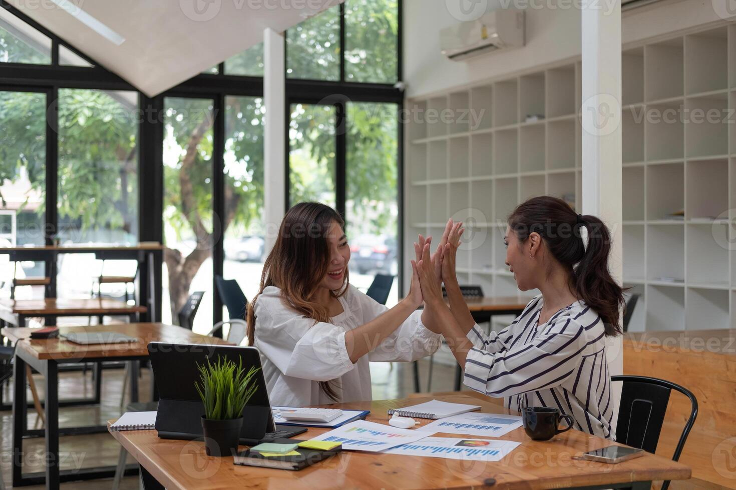 Two happy friendly business people giving high five in office celebrating success, good cooperation result, partnership teamwork and team motivation in office work photo