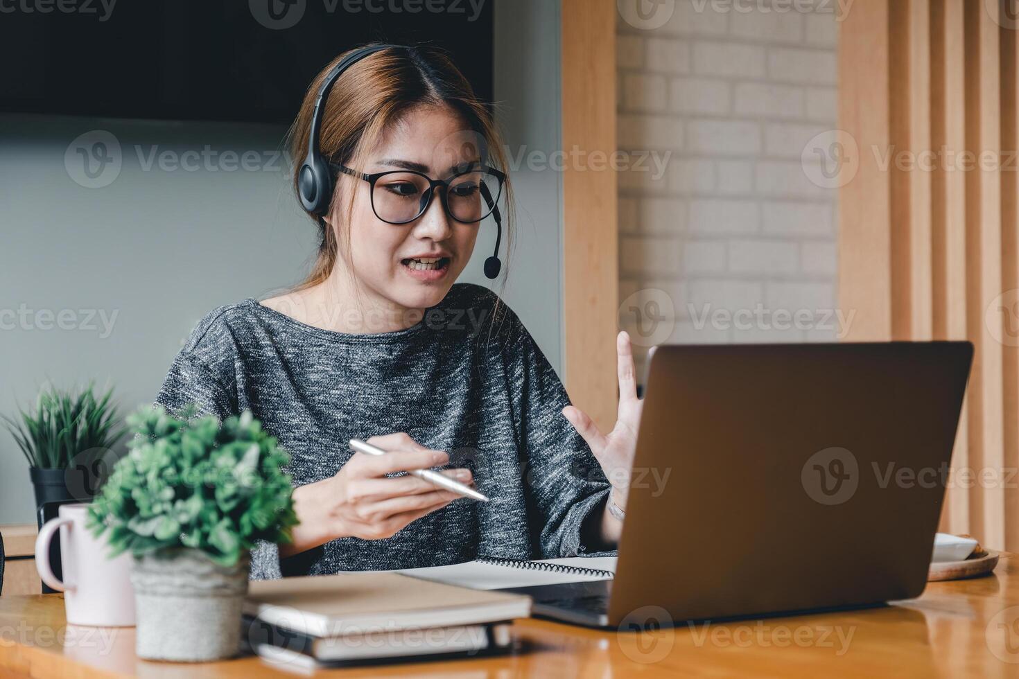 Asian woman wear headphones look at laptop enjoy study online with tutor, listen audio lecture watch webinar prepare for exams, e-learn, self education concept photo