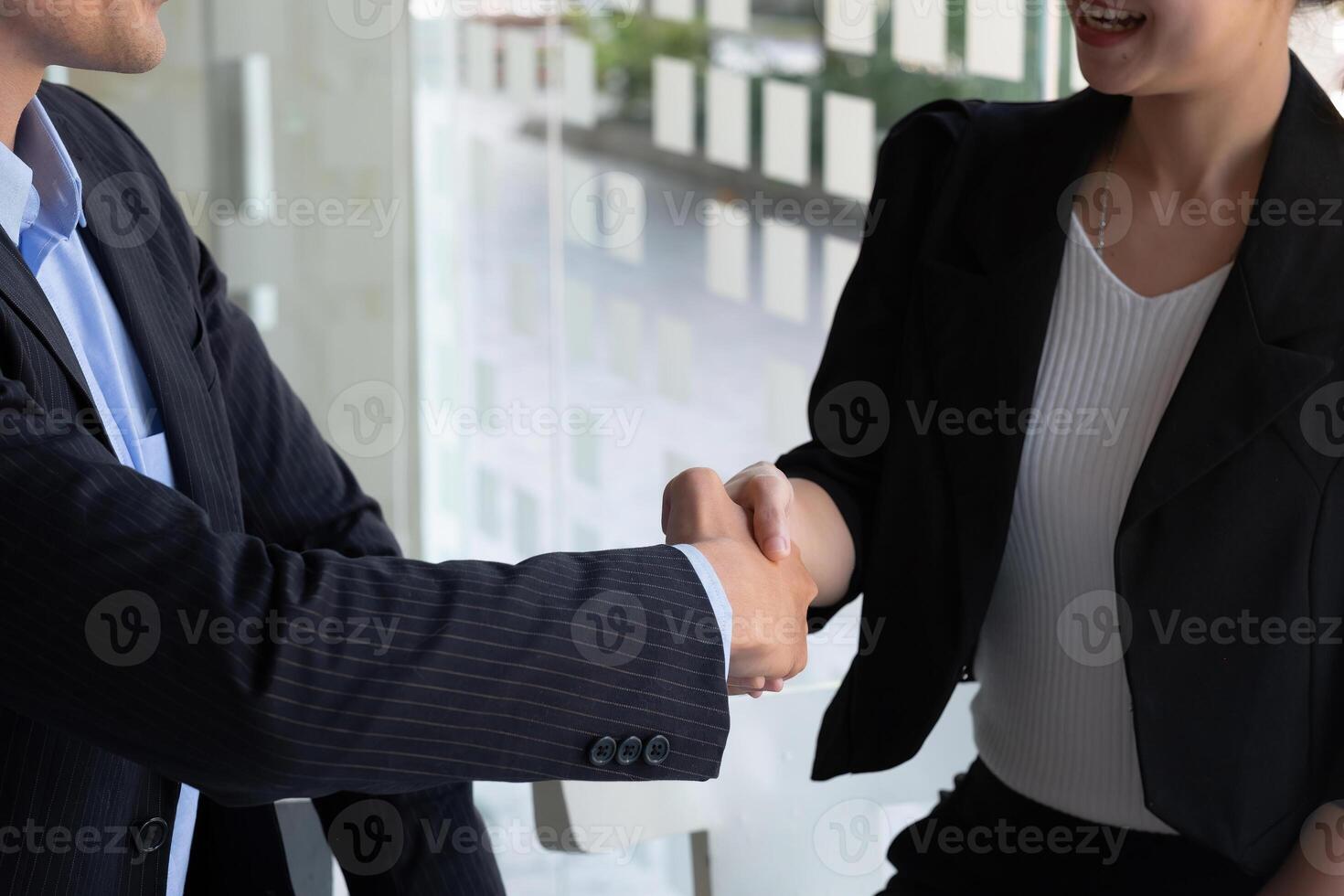 Happy caucasia male and asian female hand shaking, successful businessman handshake after good deal for both companies, business merger and acquisition concept photo