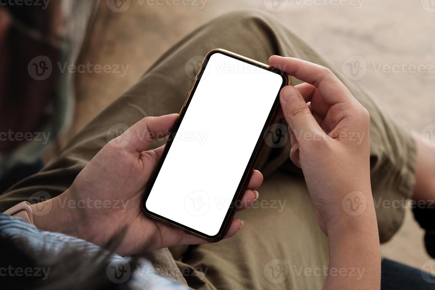 Top view woman with mask sitting and holding blank screen mock up mobile phone. photo