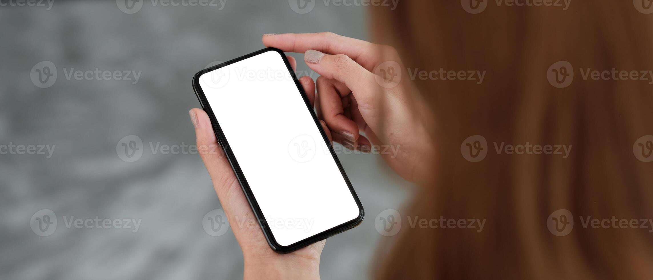 Top view Woman sitting and holding blank screen mock up mobile phone photo