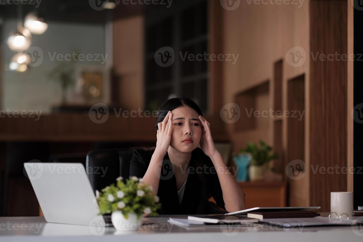 Stressed business woman working on laptop looking worried, tired and overwhelmed. asian female headache suffer from bad blurry weak vision tired of computer work syndrome, sight problem concept photo