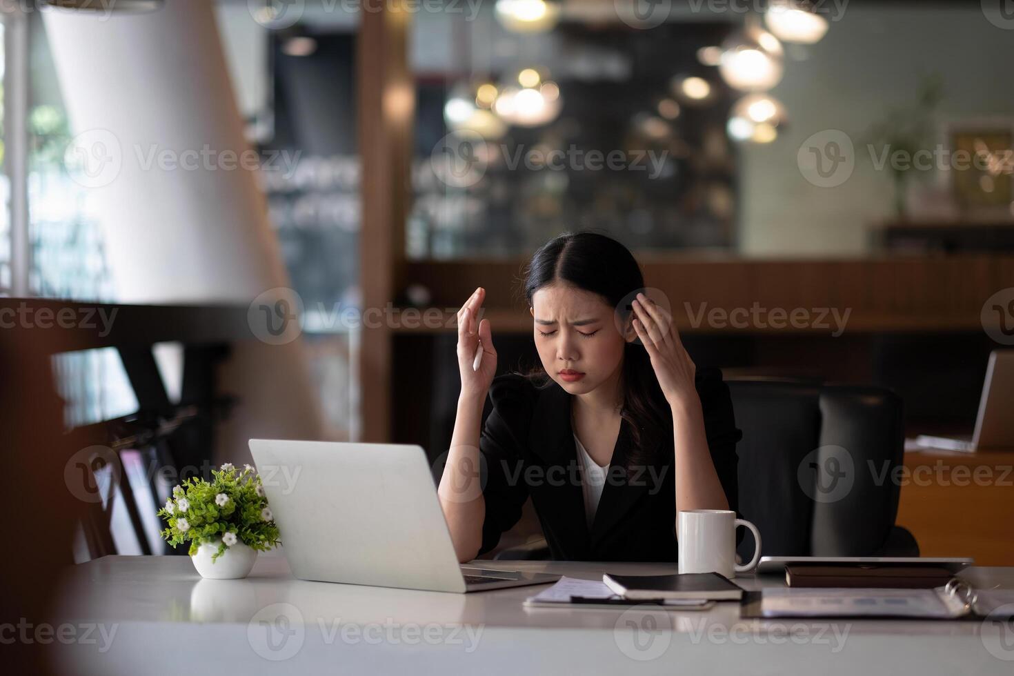 Stressed business woman working on laptop looking worried, tired and overwhelmed. asian female headache suffer from bad blurry weak vision tired of computer work syndrome, sight problem concept photo