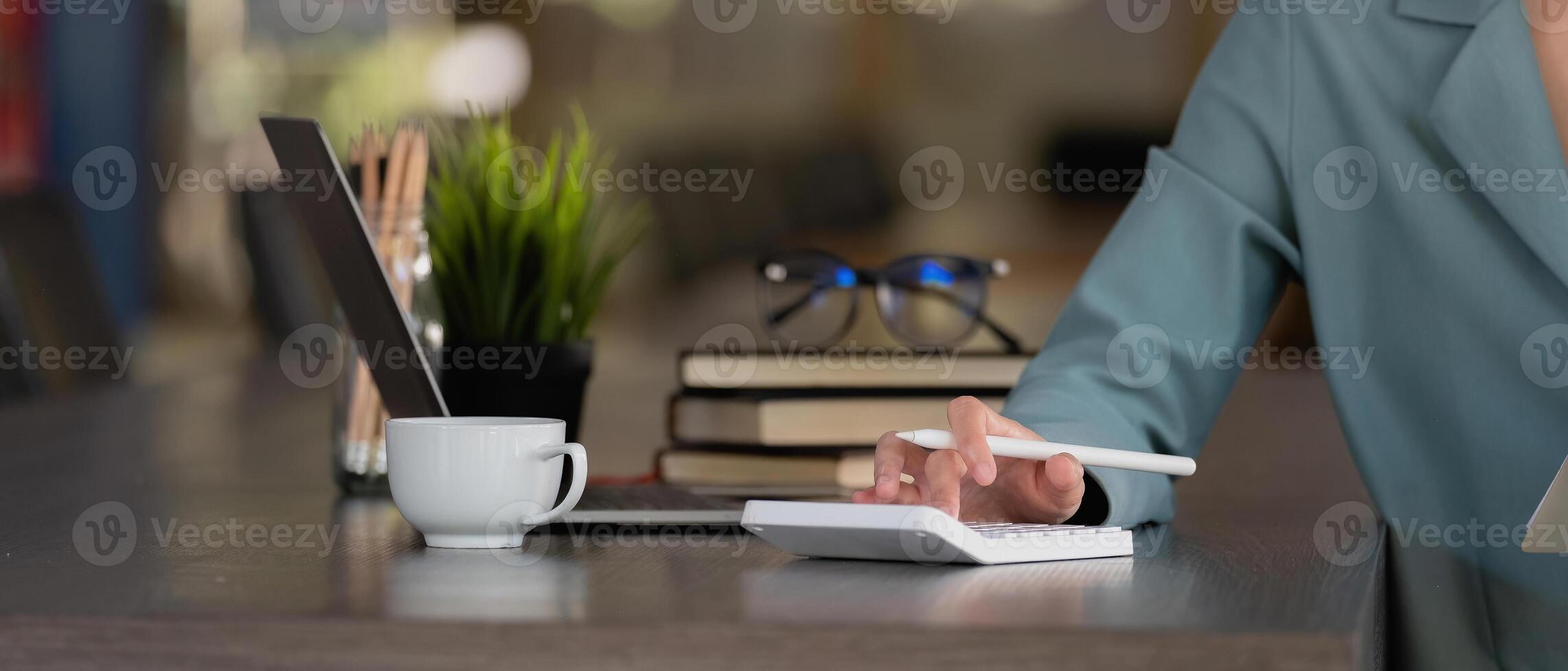 Close up businesswoman using calculator for analysis maketing plan, Accountant calculate financial report, computer with graph chart. Business, Finance and Accounting concepts photo
