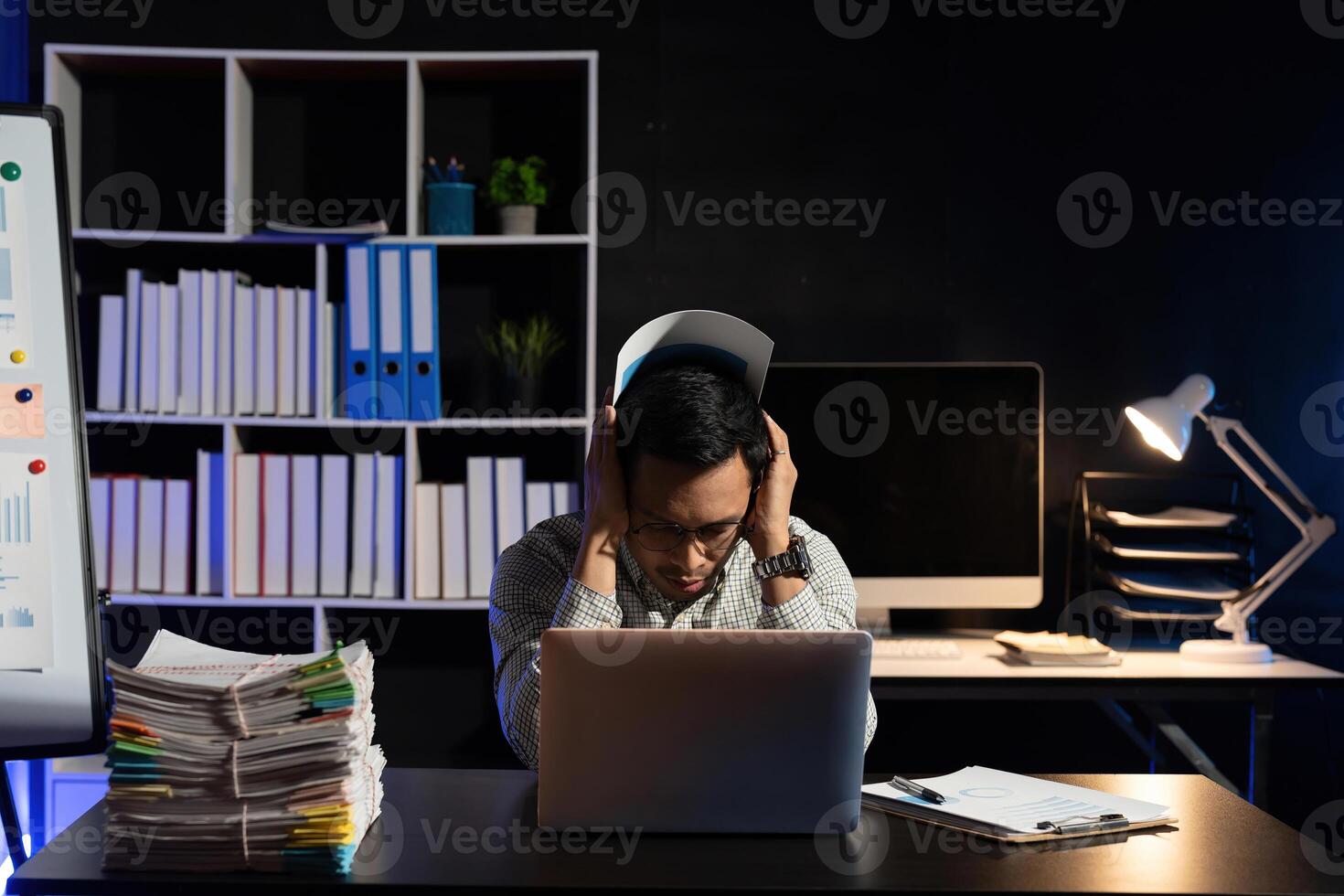 Businessman making mistake about financial business.Exhausted and tired worker surrendering to fatigue working and sleepy worker on desk with laptop on head after late night work at office photo