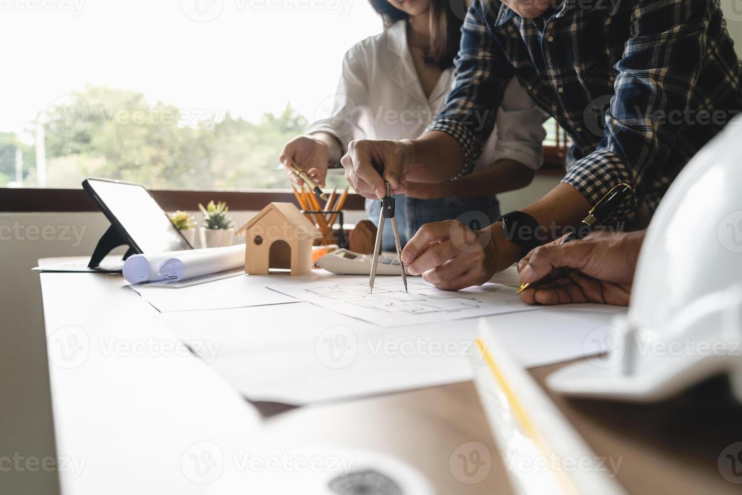 Close up of engineer hand drawing plan on blue print with architect equipment, Architects discussing at the table, team work and work flow construction concept. photo