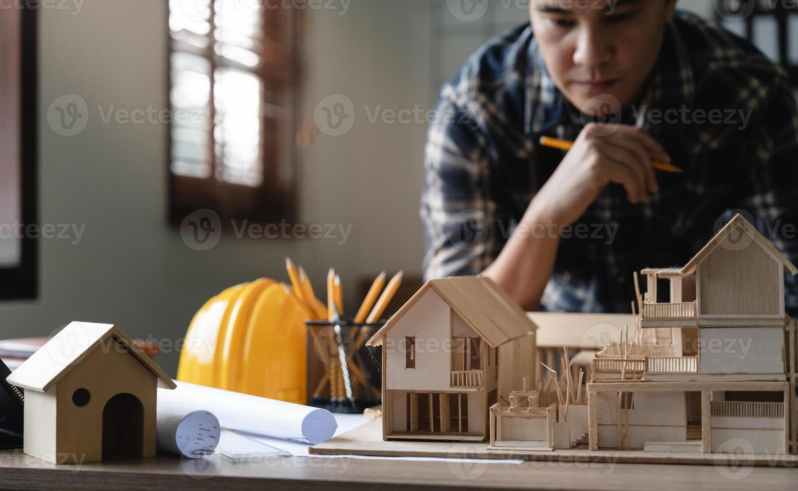 Engineer architect designer freelance work on start-up project with home model, construction plan. architect design working drawing sketch plans blueprints and making construction model. Architects photo