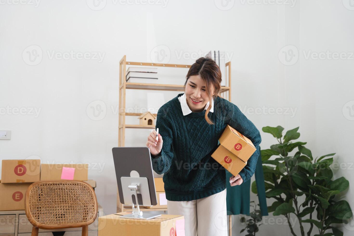 Asian woman freelancer sme business online shopping working with parcel box at home - SME business online and delivery concept photo