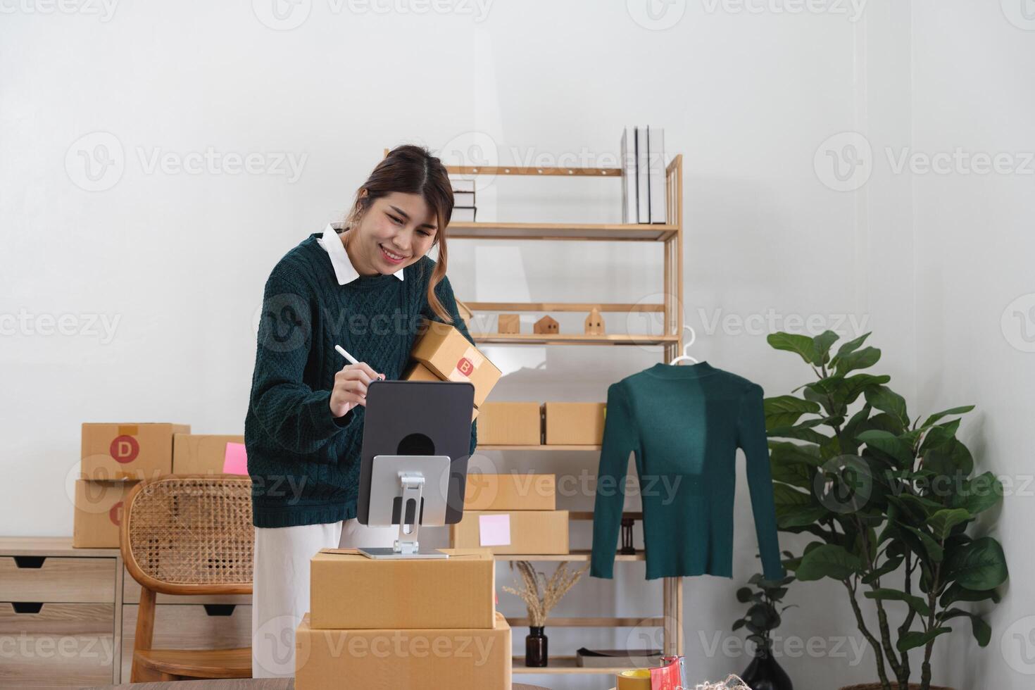Asian woman freelancer sme business online shopping working with parcel box at home - SME business online and delivery concept photo