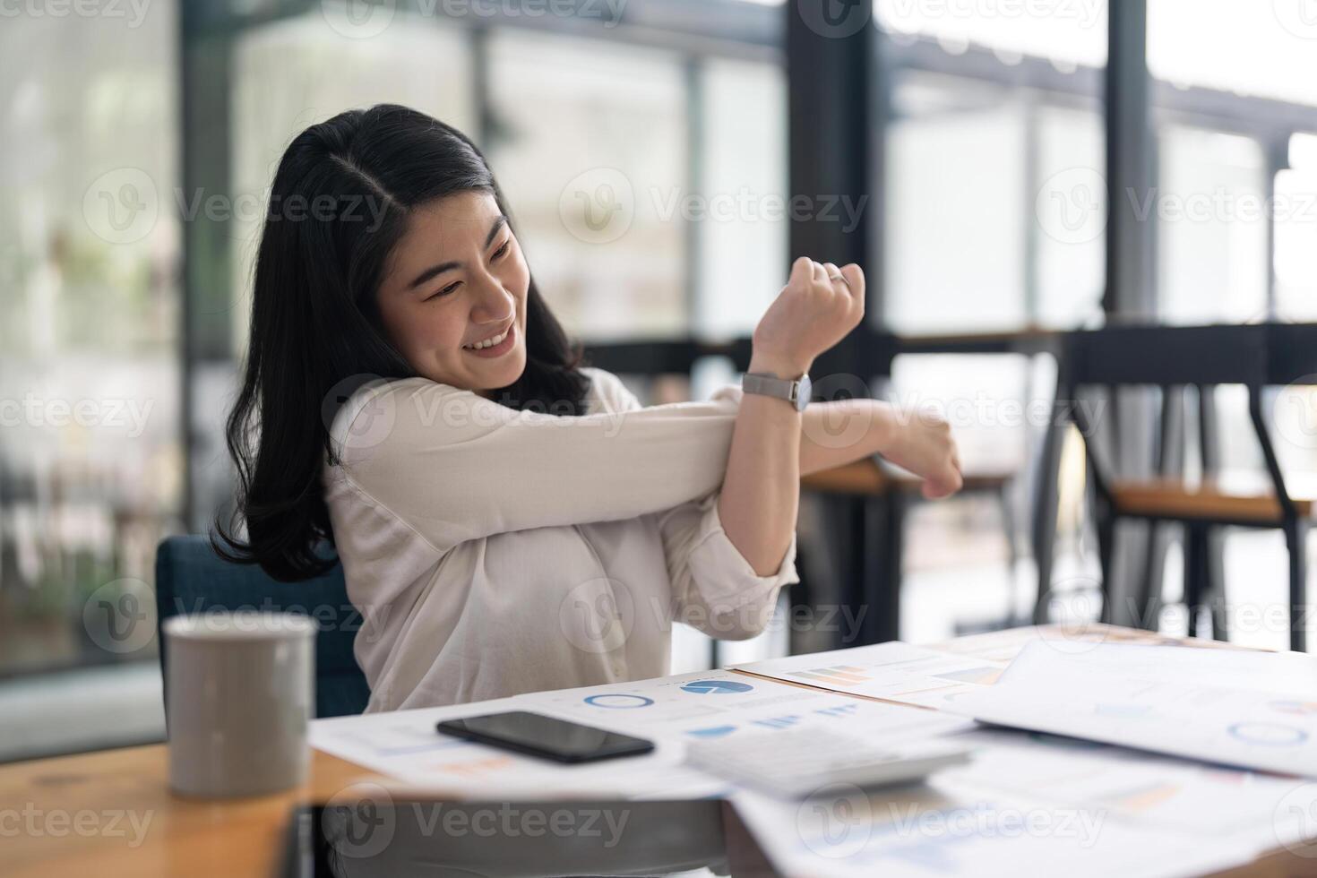 Young Asian Business Accountant woman stretching herself and relax while working hard photo
