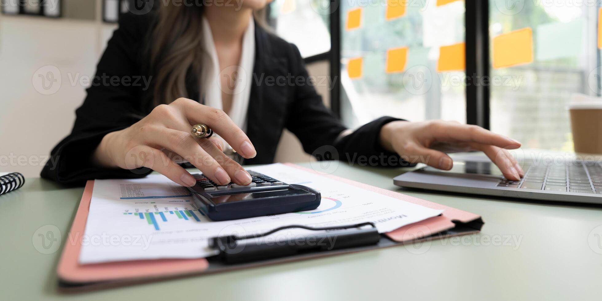 Close up hands business accoutant woman doing finances with using calculator and using laptop computer. photo