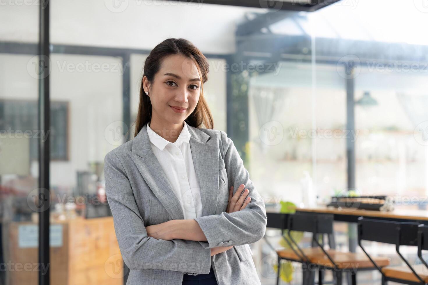 portrait Working woman asian wearing a gray suit, smiling, Crossed hands looking at the camera with confidence at office photo