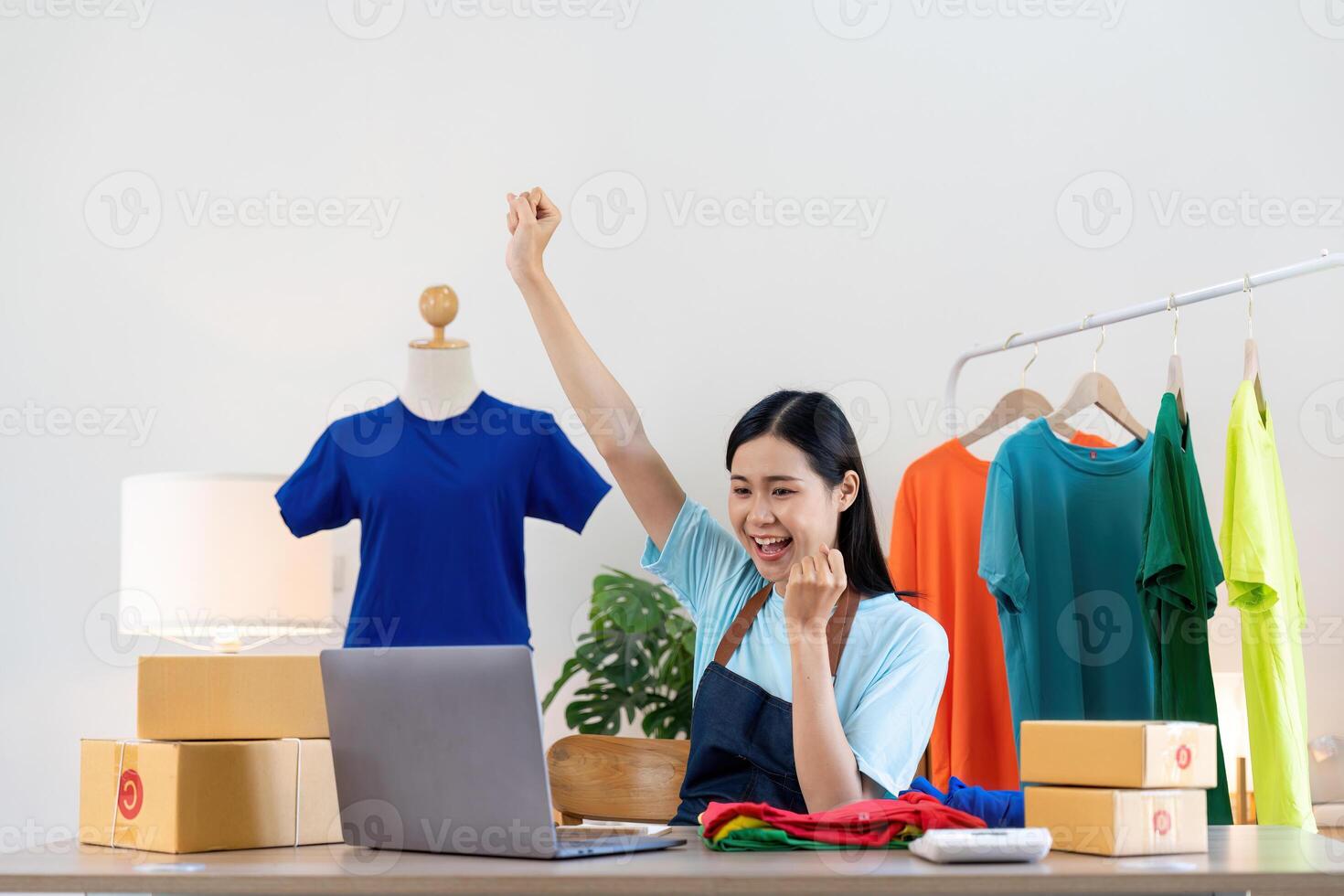 Happy exciting successful asian woman doing clothing business selling online. she using laptop computer. online sell marketing delivery, SME e-commerce telemarketing concept photo