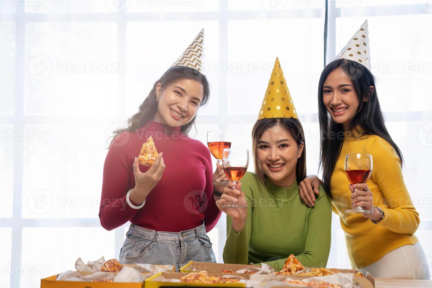 Group of Asian friends gather to celebrate Christmas with champagne and eating pizza at home. Joy of holiday party with friends or colleague concept photo