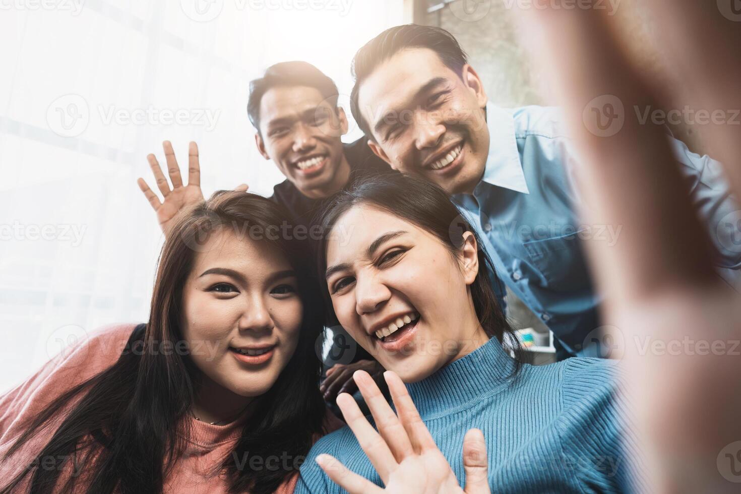 Friends watch sports on TV, cheer and celebrate. Happy diverse asian friend supporters fans sit on couch with popcorn and drinks. call on mobile phone photo
