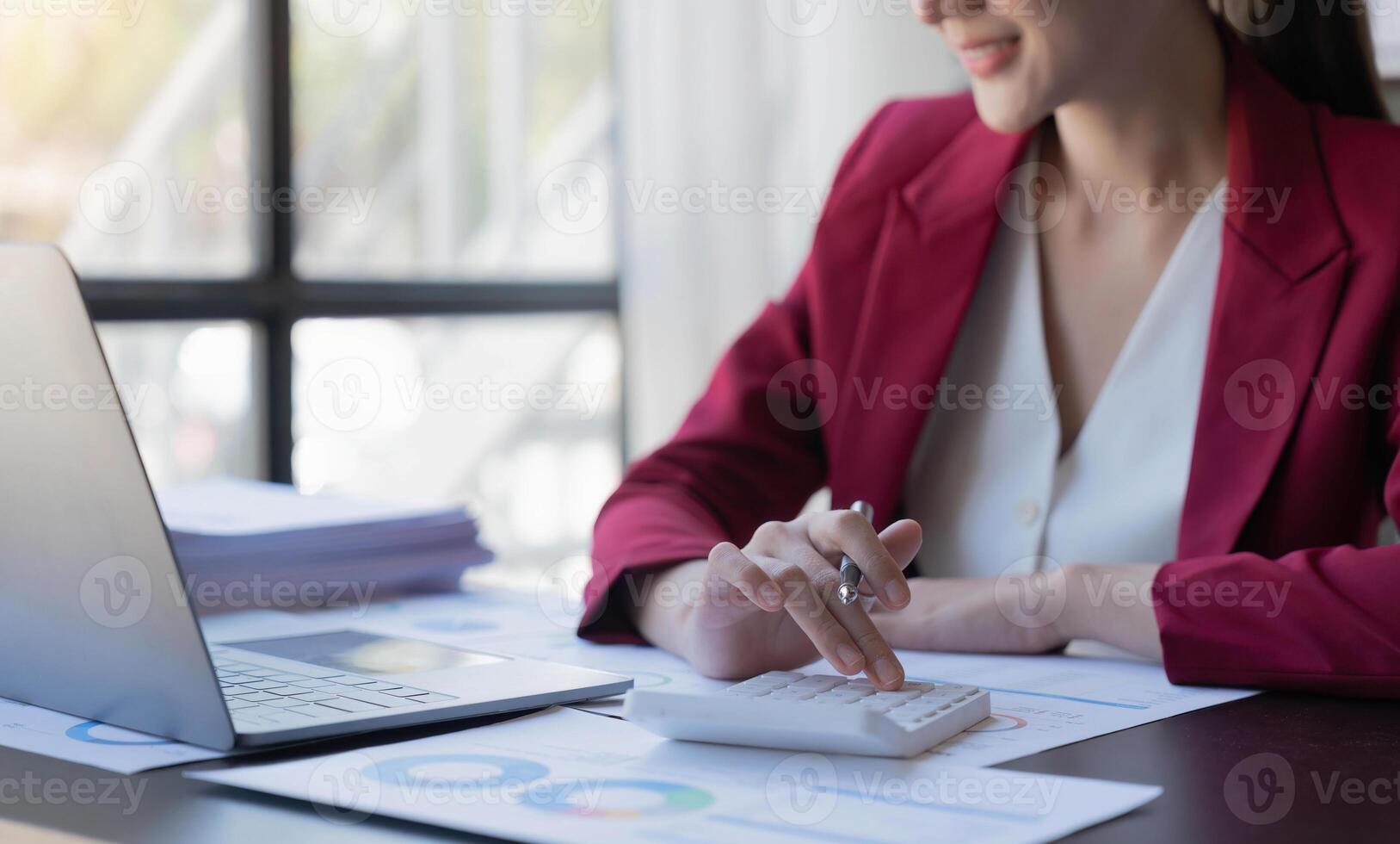 Close-up woman hand press calculator to calculate the company's financial results in the office and business work background, tax, accounting, statistics, and analytical research photo