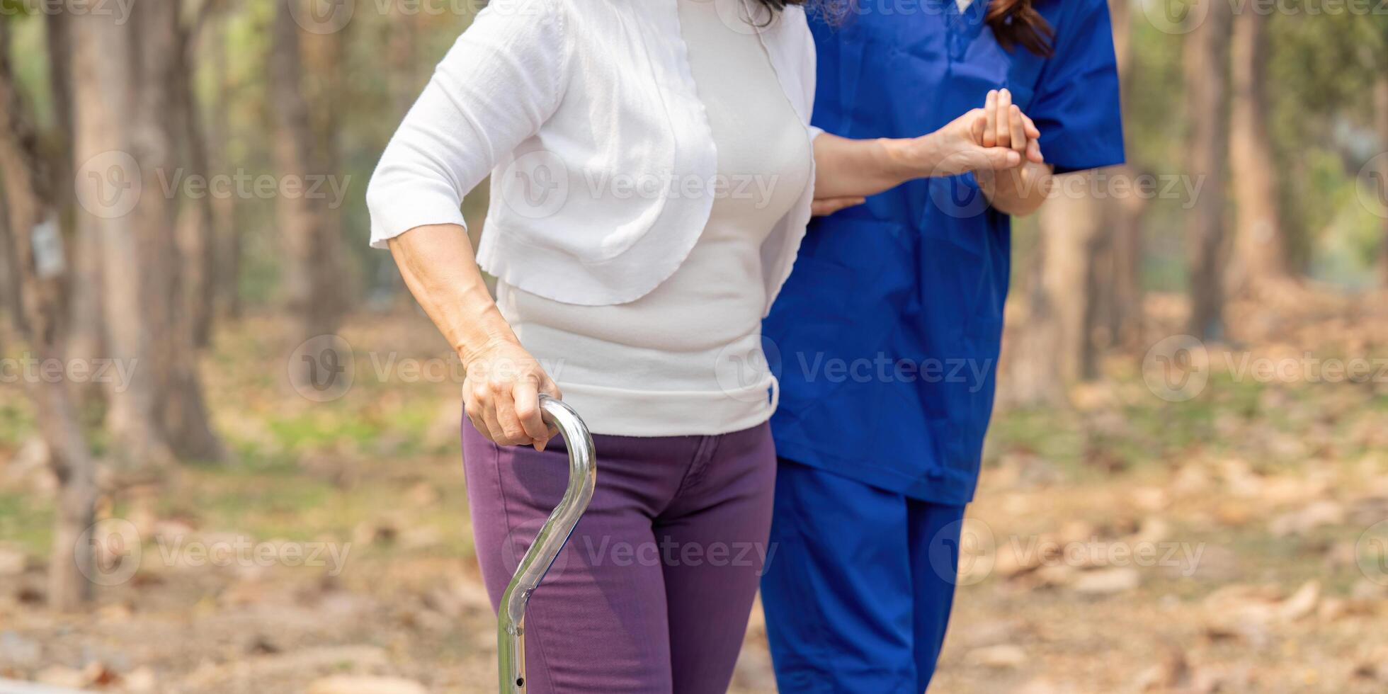 Nurse and senior in elderly care, support or walking with stick at park. Medical caregiver or therapist help patient or person with a disability in retirement or physiotherapy photo