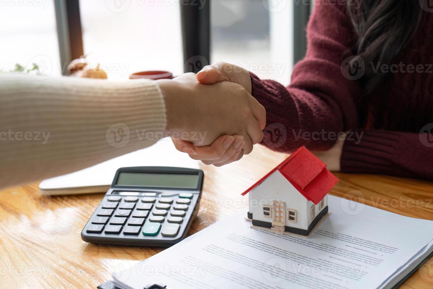 The bank mortgage officer or real estate agent handshake with customer deal after signing a house insurance, loan contract agreement photo