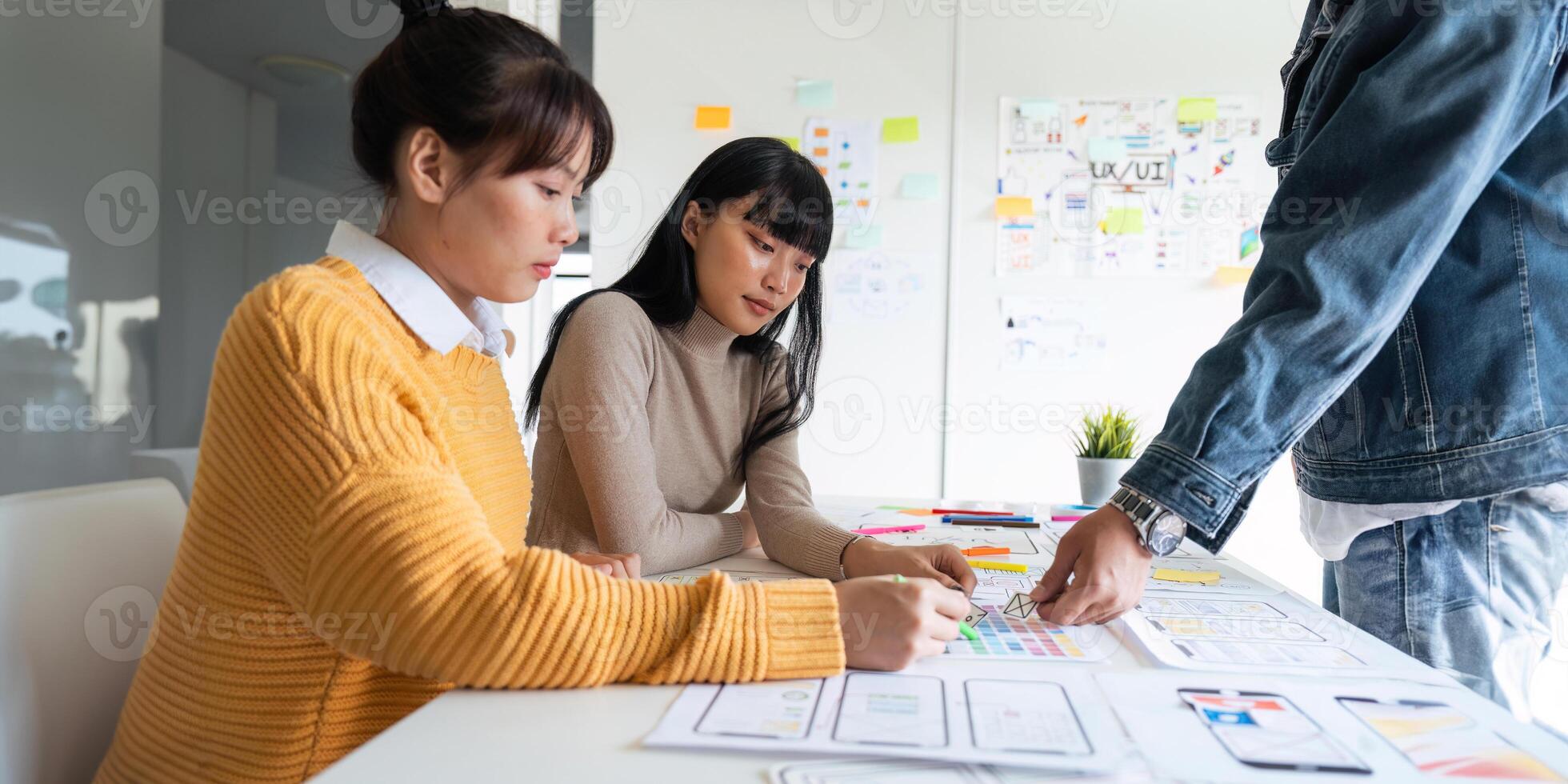 ux developer and ui designer use augmented reality brainstorming about mobile app interface wireframe design on desk at modern office photo