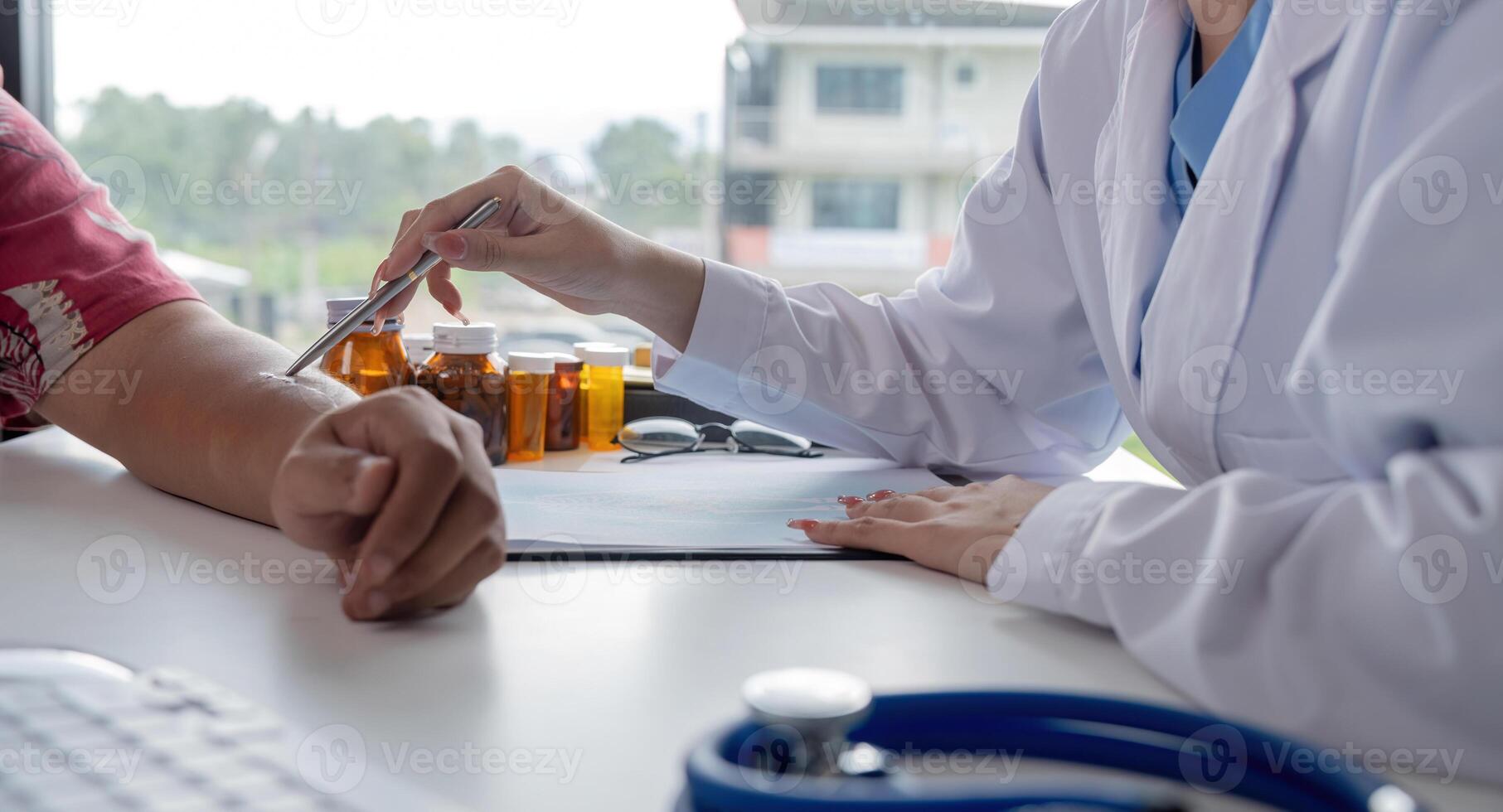 Physician discuss results or symptoms and gives a recommendation to a male patient and signs a medical paper at an appointment visit in the clinic photo