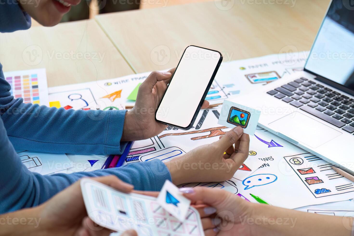 Blank screen mockup of man hand working on smartphone work while sitting at the table, mockup blank screen for brainstorming about mobile app interface wireframe design on desk at modern office photo