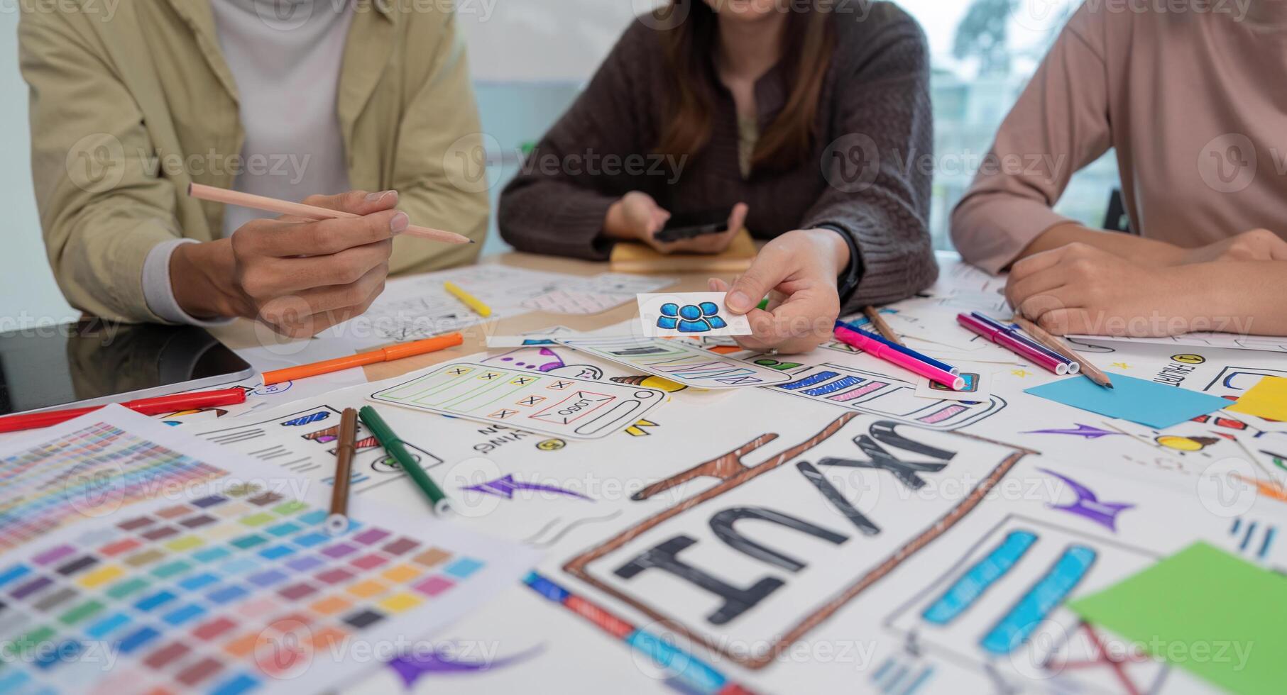 UX developer and ui designer brainstorming about mobile app interface wireframe design at modern office photo