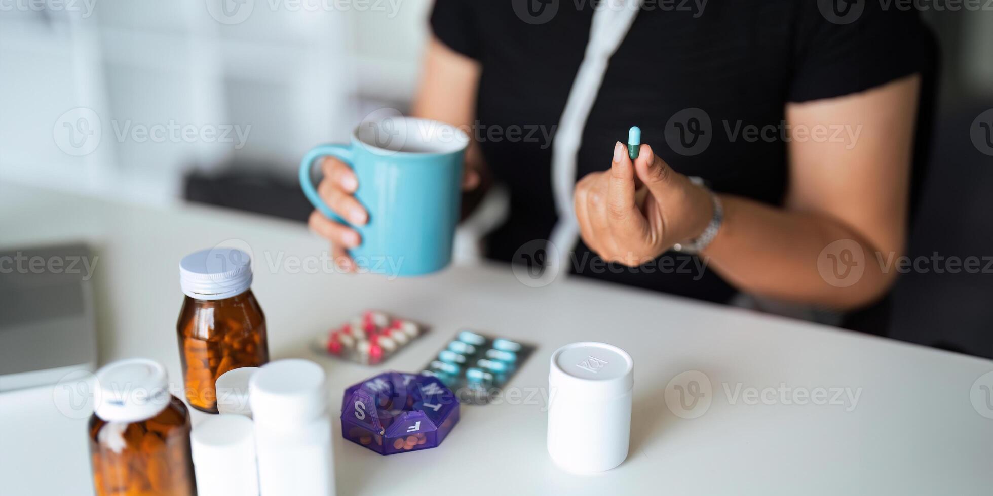 Close up woman holding pill in hand with water feeling sick. female going to take painkiller from headache, painkiller, healthcare, medicine, treatment, therapy, patient, disease illness concept photo