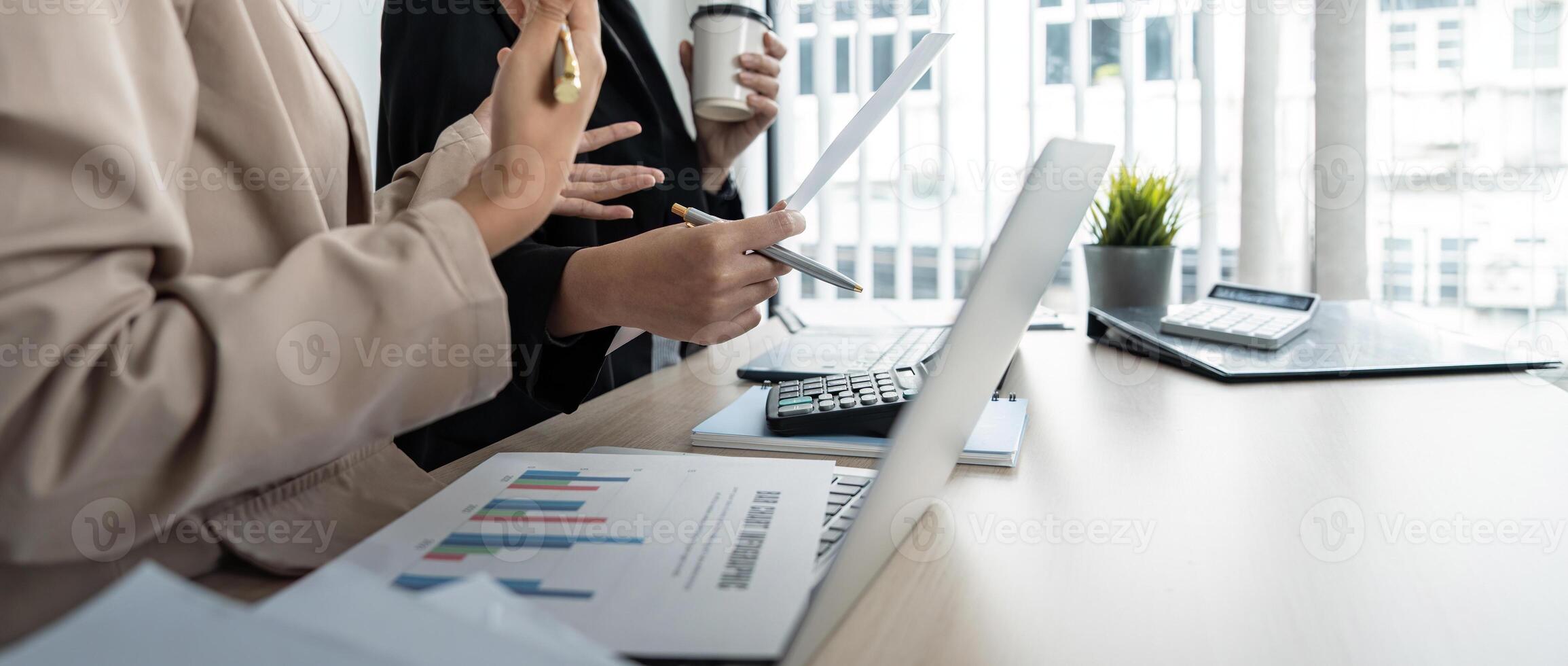Business team and two colleague discuss data from graph financial chart and document use laptop to contact negotiations. Planning on the office desk, startup business concept photo