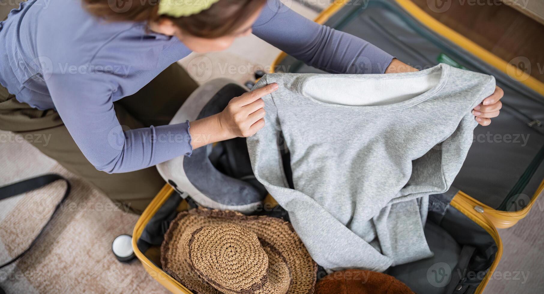 Traveler woman packing prepare stuff and outfit clothes in suitcases travel bag luggage for holiday at home, weekend, tourist, journey photo