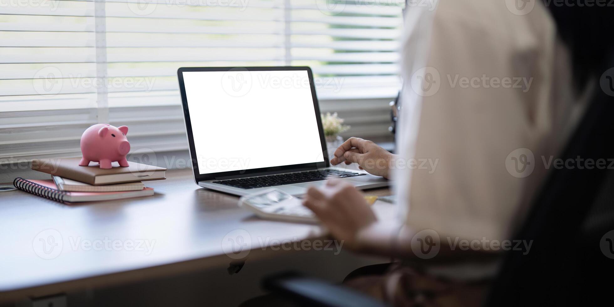 Laptop screen mock up, laptop in blank empty screen on the desk in home while woman working on financial calculating photo