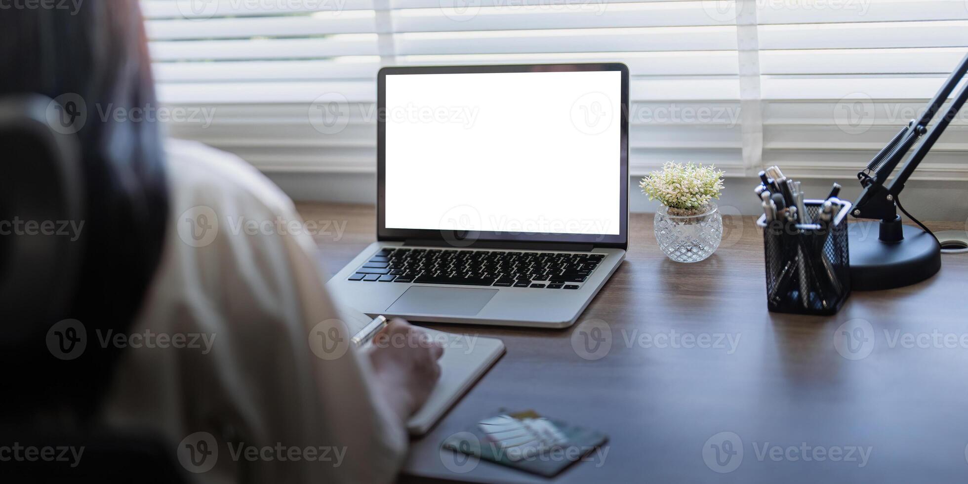 Laptop screen mock up, laptop in blank empty screen on the desk in home while woman working on financial calculating photo