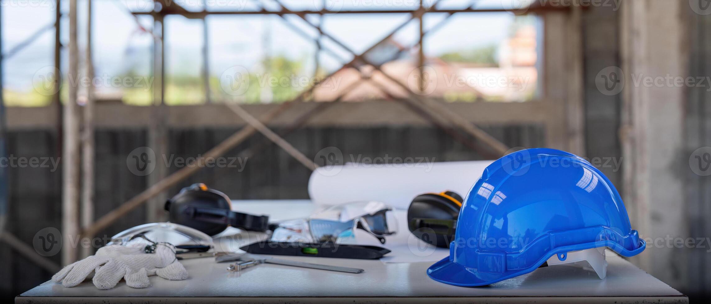 Engineer tool architecture blueprint design and safety helmet hardhat on meeting table with contractors paper project with engineer and architect working and discussing in background photo