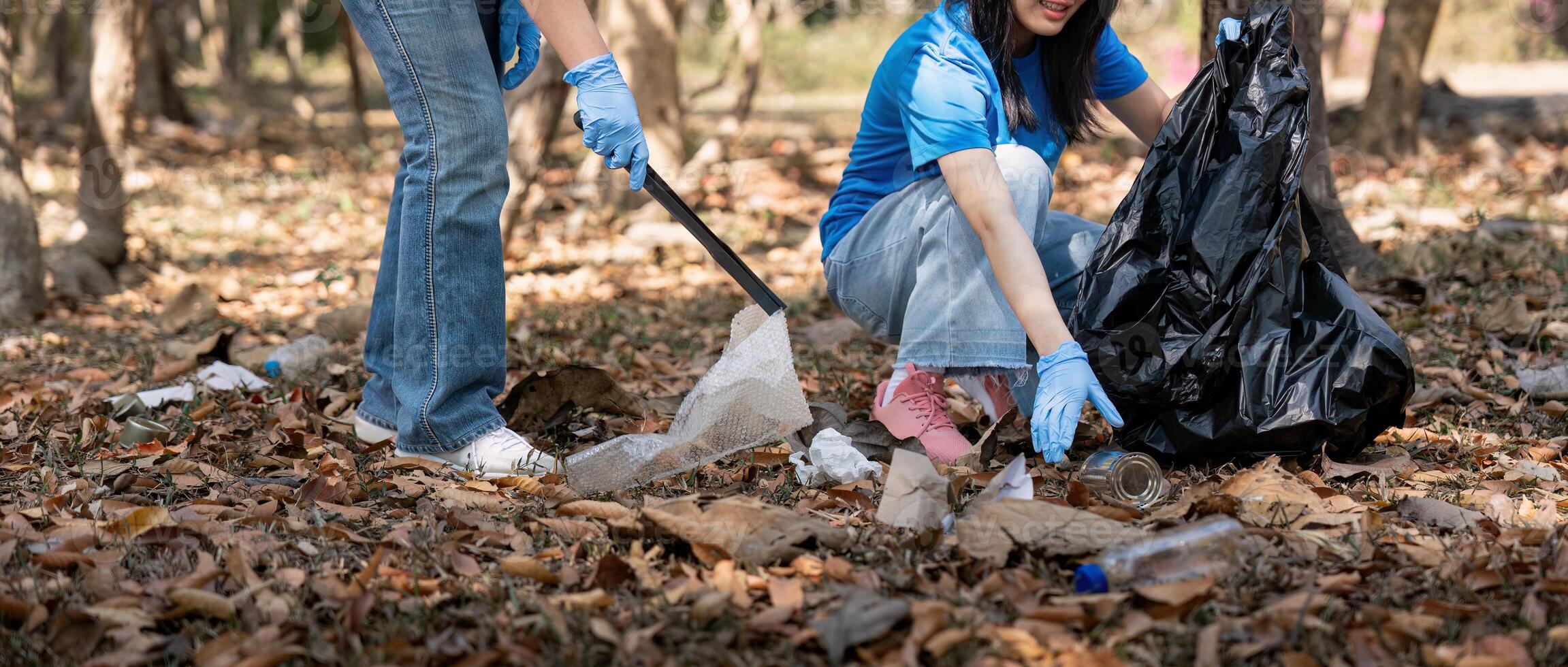 Volunteer collecting plastic trash in the forest. The concept of environmental conservation. Global environmental pollution. Cleaning the forest photo