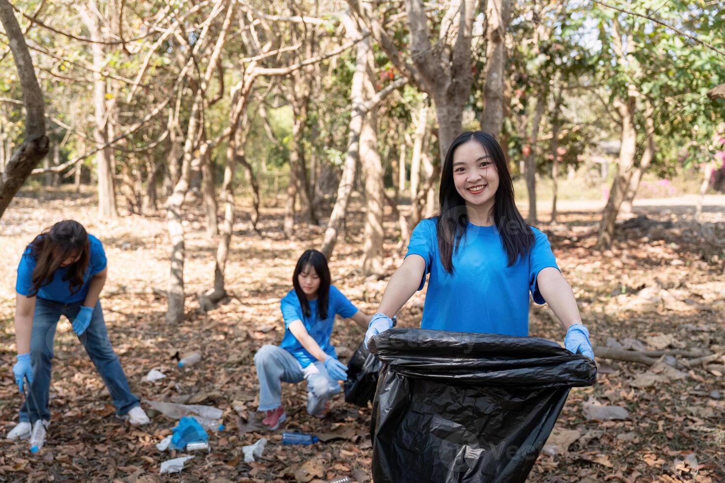 Volunteer collecting plastic trash in the forest. The concept of environmental conservation. Global environmental pollution. Cleaning the forest photo