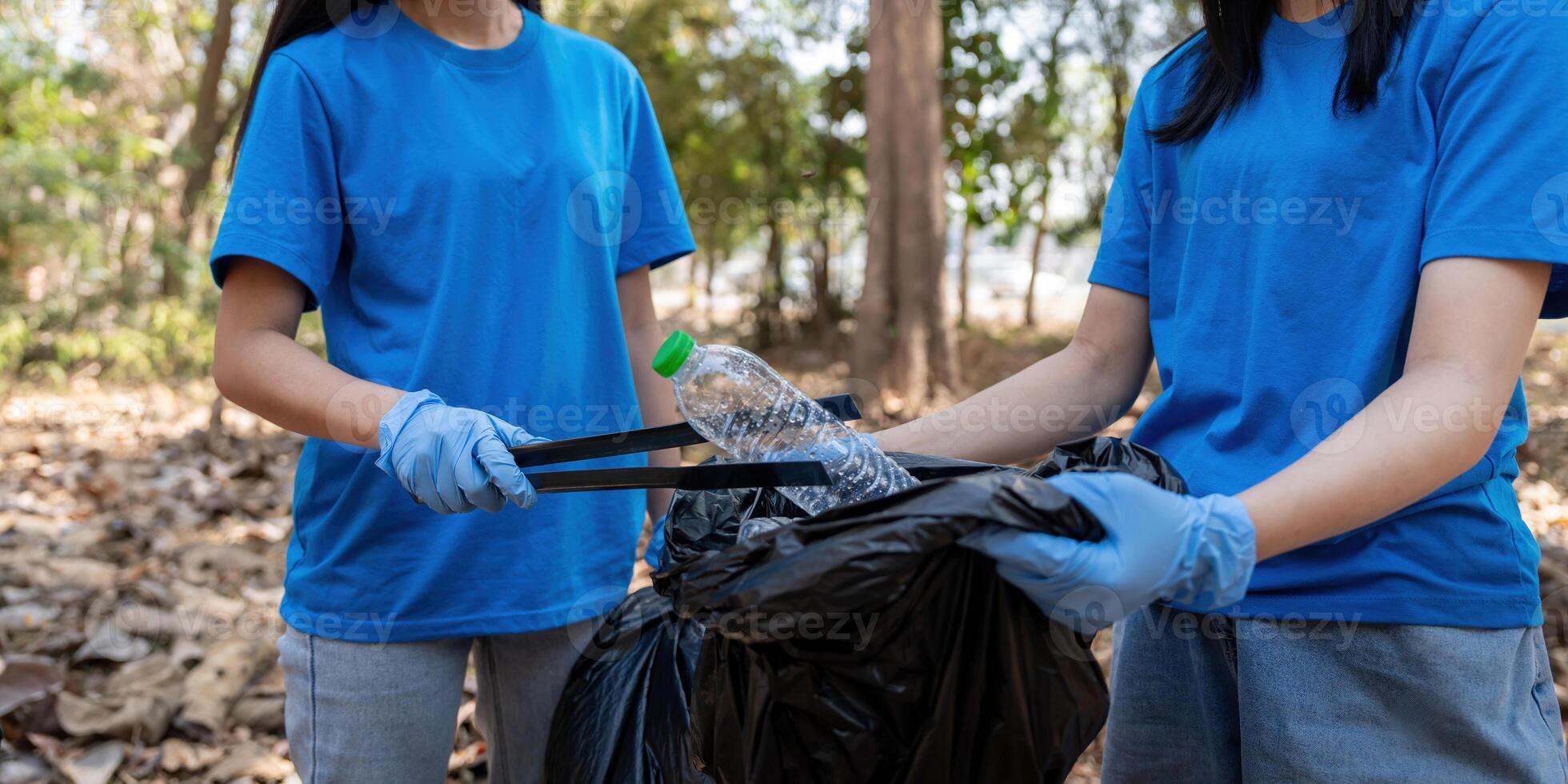Volunteer collecting plastic trash in the forest. The concept of environmental conservation. Global environmental pollution. Cleaning the forest photo