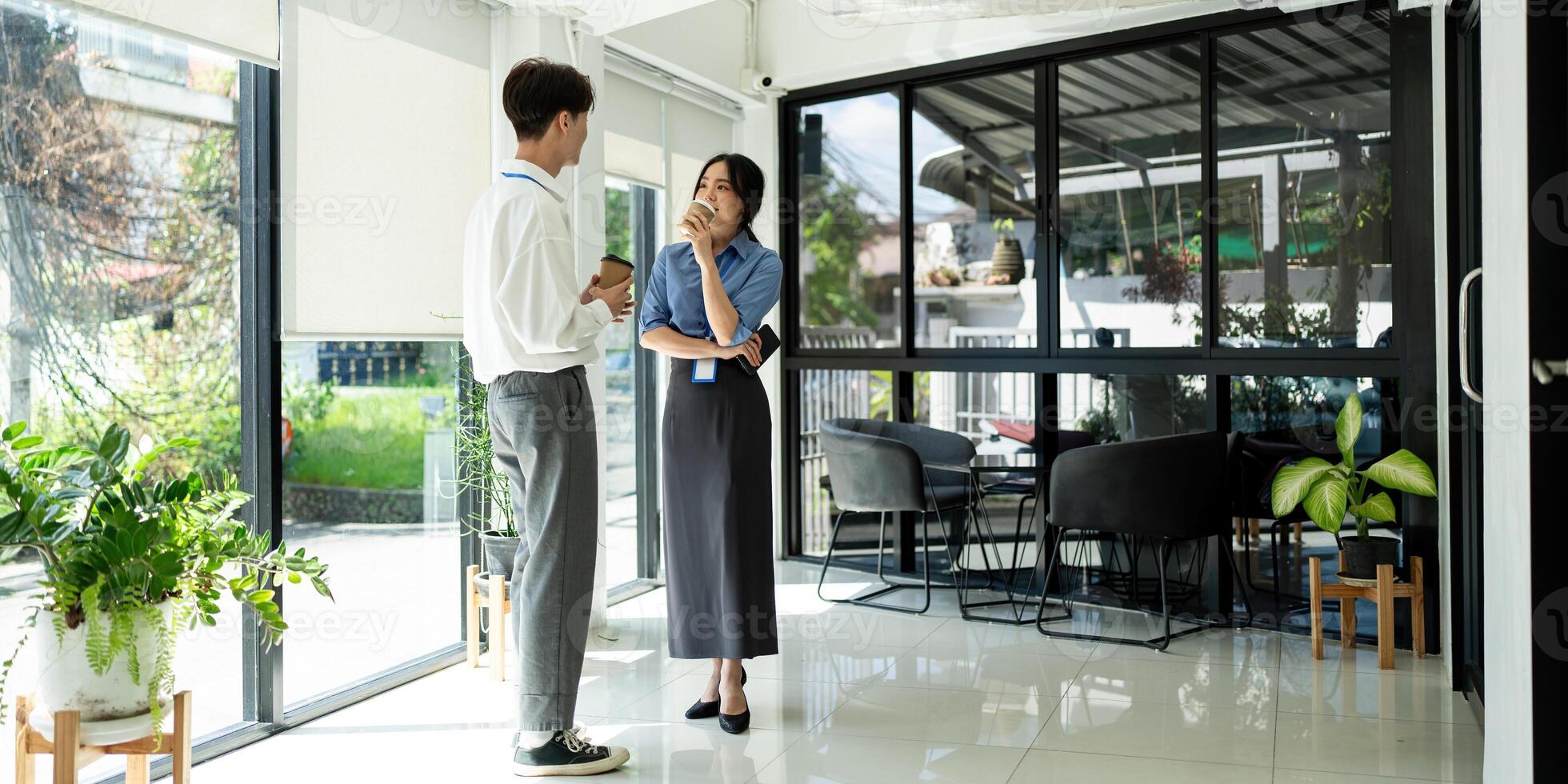 Two happy business people team asian discussing new project at workplace during coffee break in office photo