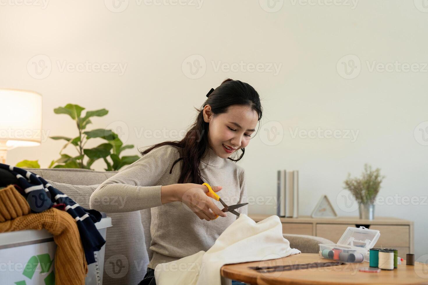 Woman repairs sews reuses fabric from old clothes economical reuse. DIY Hobby Reuse Recycling at home photo