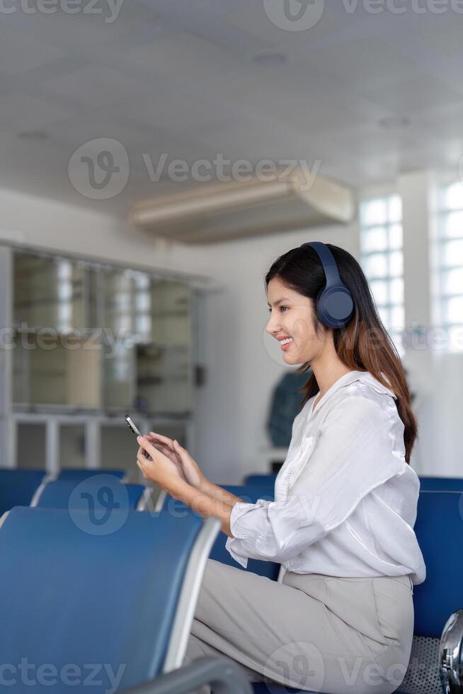 Asian woman waiting at airport terminal. Concept of travel and anticipation photo