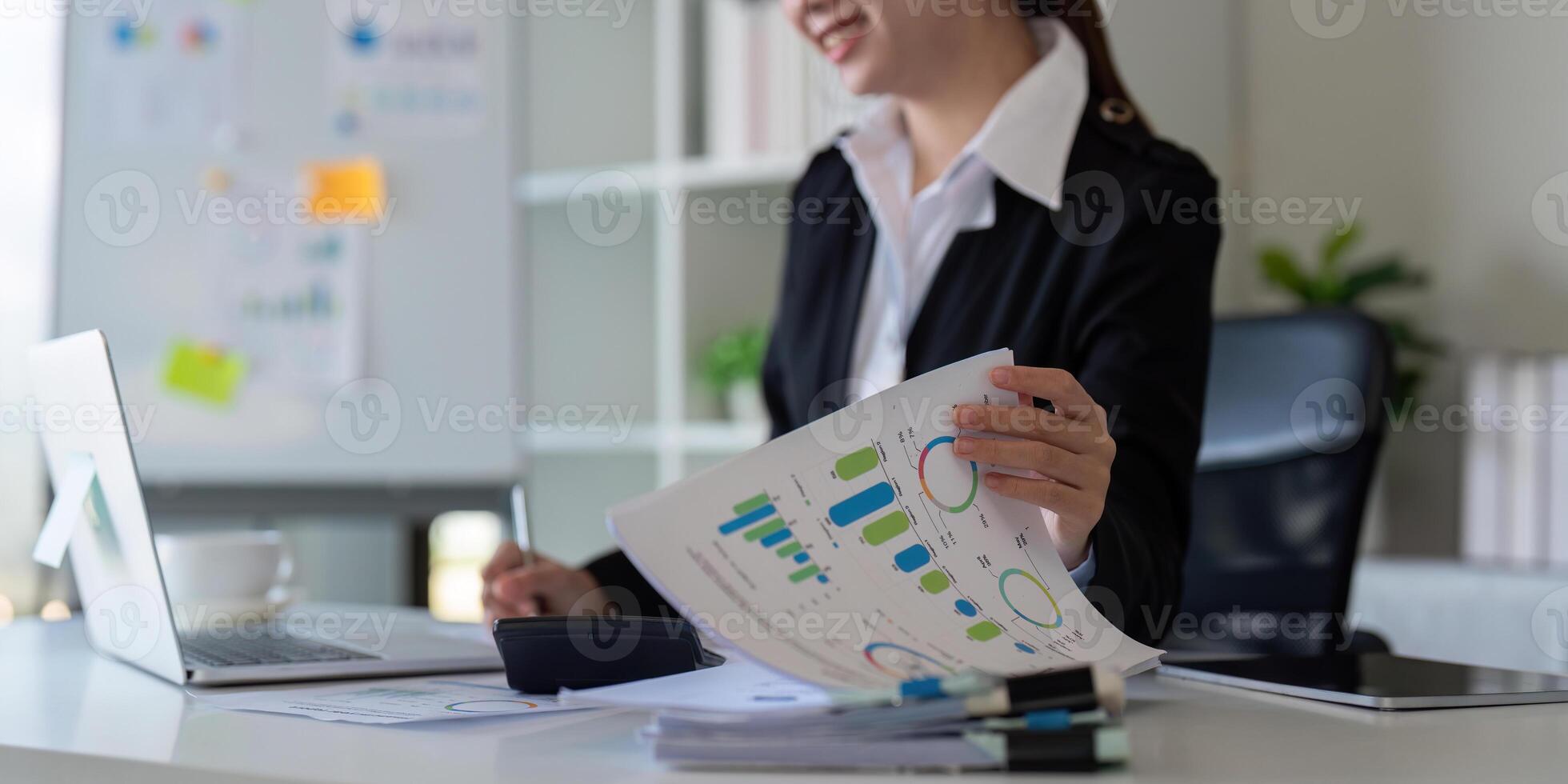 Businesswoman analyzing charts in office. Concept of finance, technology, and productivity photo