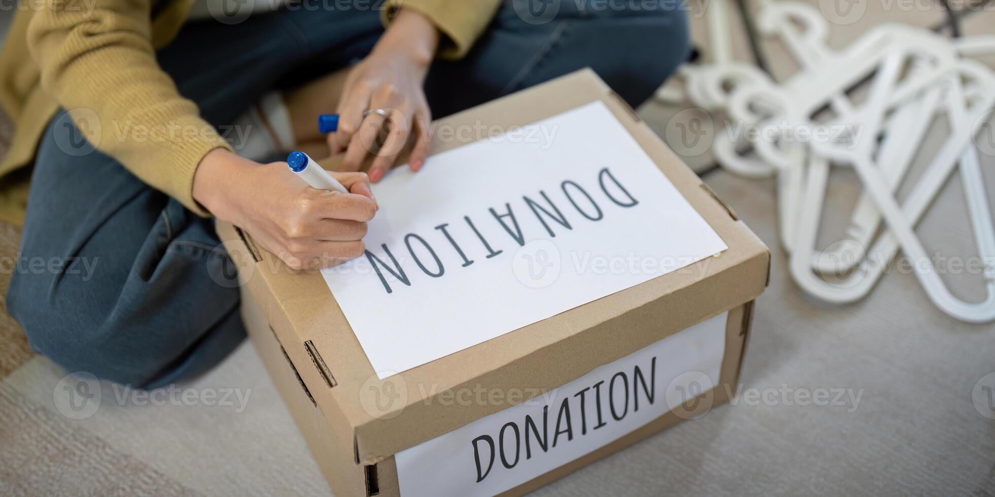 Close up of a person labeling a donation box at home. Concept of charity, giving, and community support photo