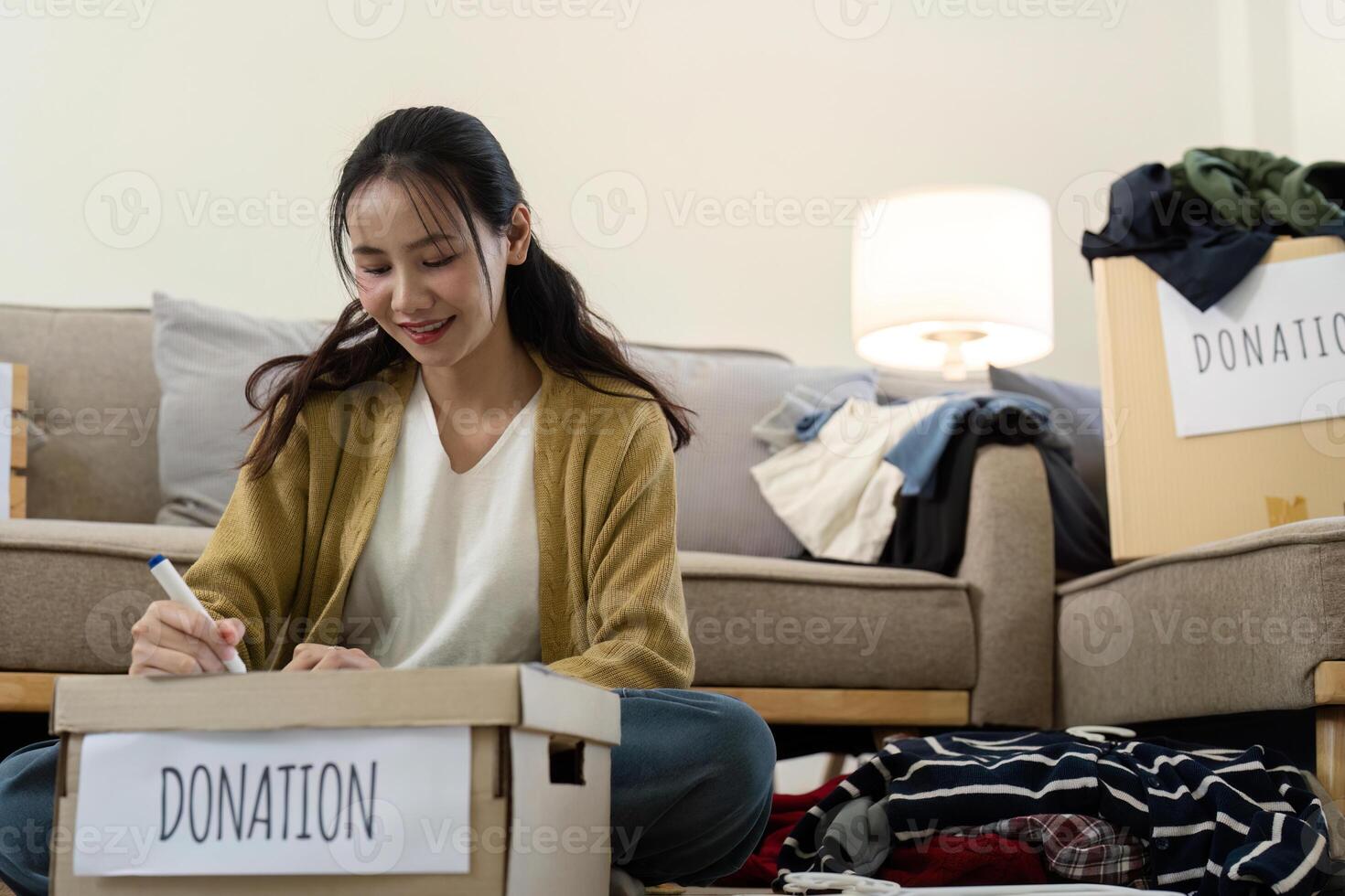 Woman preparing donation boxes at home. Concept of charity, giving, and community support photo