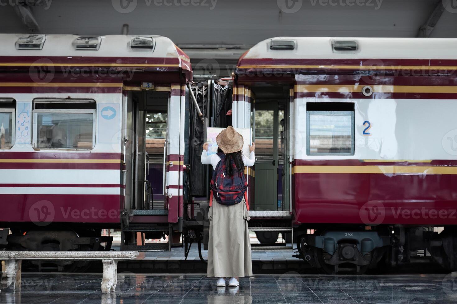 Young woman with suitcase for tourist adventure holiday traveling standing and looking at the map with a train. concept transport lifestyle active journey and travel lifestyle travel photo