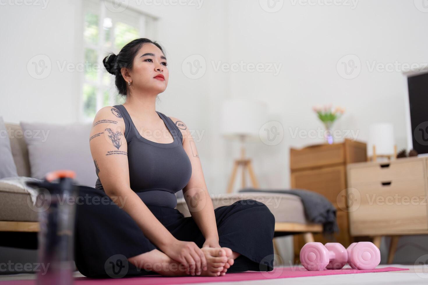Confident Woman Practicing Yoga at Home, Embracing Healthy Lifestyle and Weight Loss Journey, Sitting on Yoga Mat with Dumbbells in Modern Bedroom, Promoting Fitness and Self Care photo