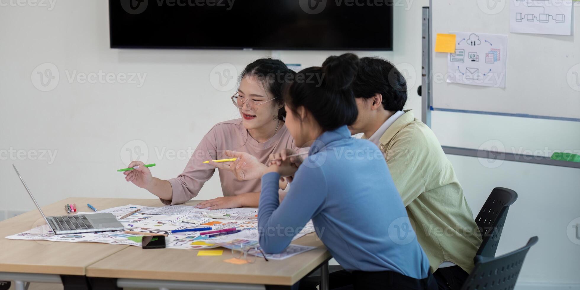 Creative UX Developer and UI Designer Team Brainstorming Ideas in Modern Office Setting with Laptops and Sketches photo